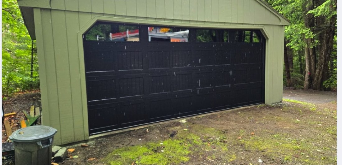 Garage door installed on green-sided building