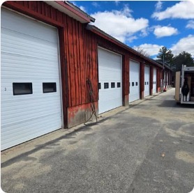 Row of white doors on red barn-style commercial building
