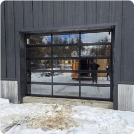 Full-view glass panel garage door installed, snow on ground
