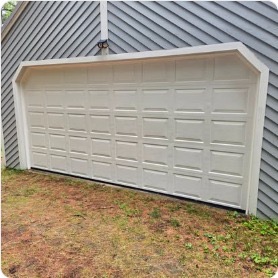 White garage door installed on gable-roofed home