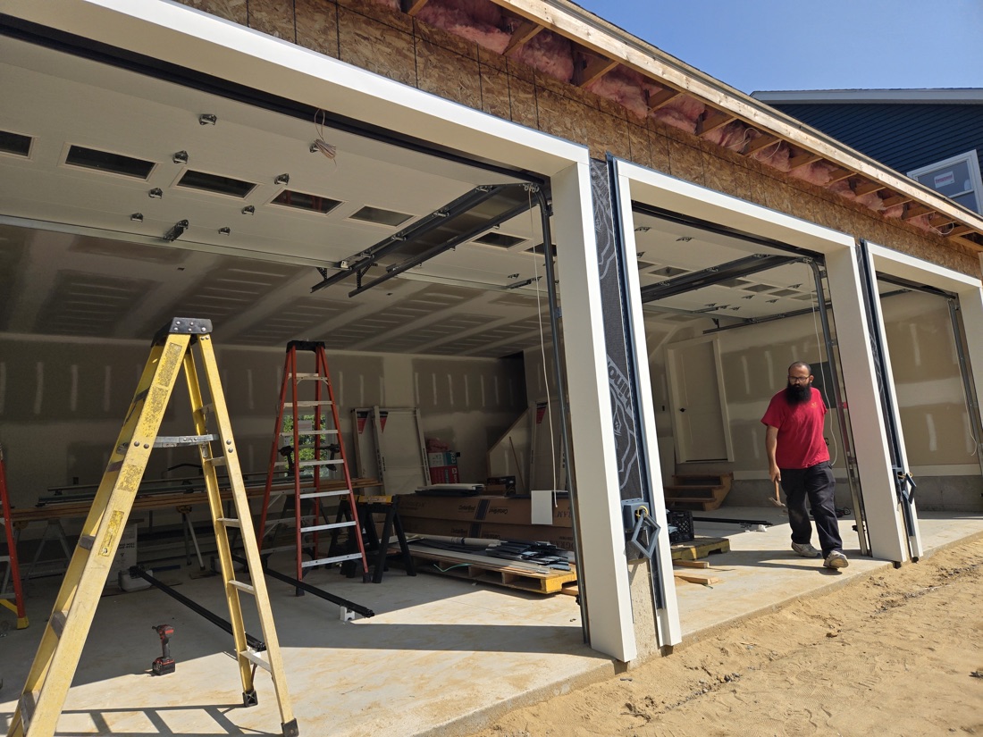 Three-bay garage under construction with framing and door tracks installed
